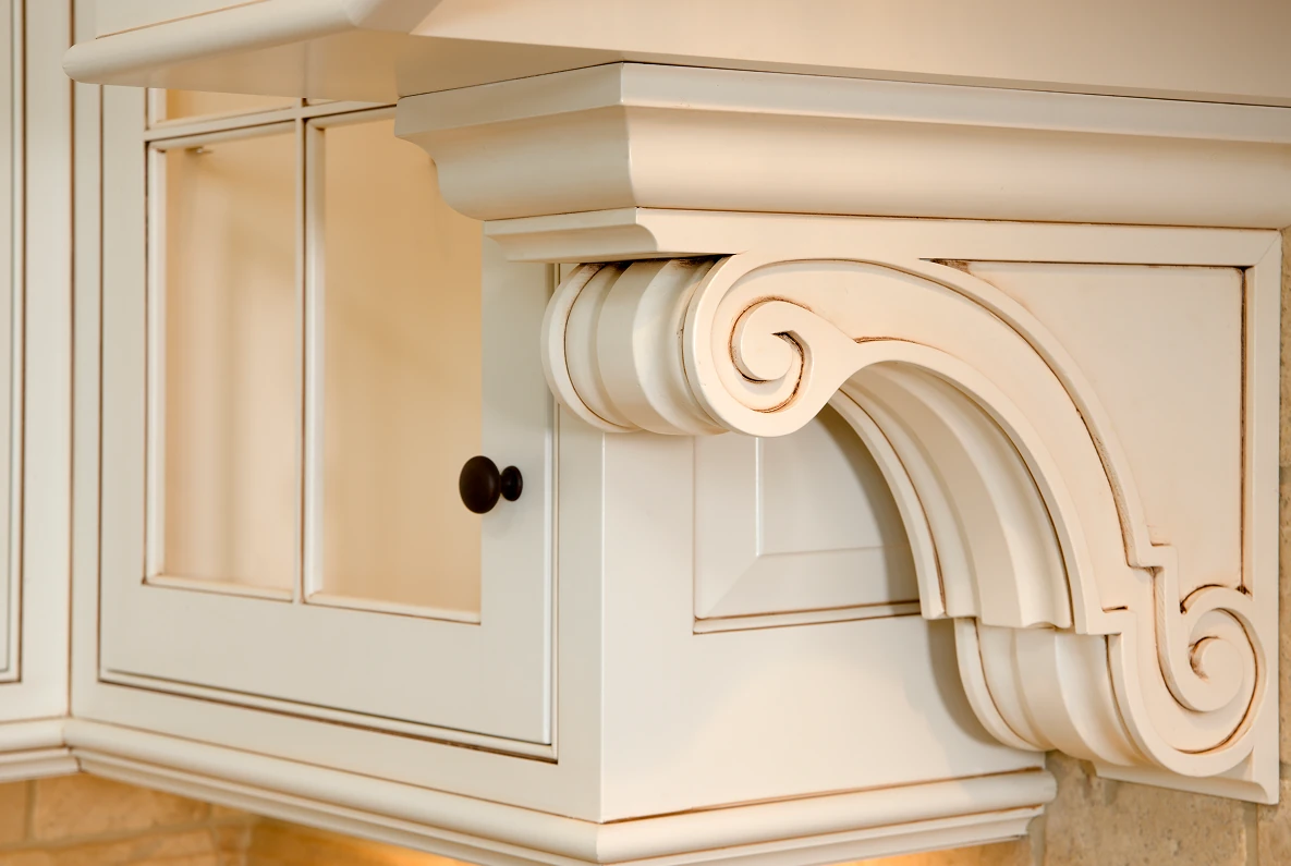 White ornate kitchen cabinet corbel detail.