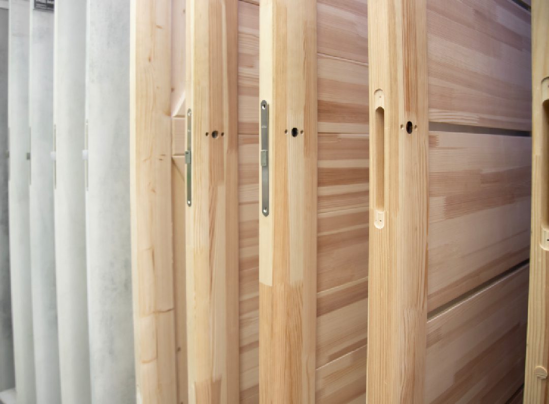 Close-up of wooden doors with metal handles and locks.