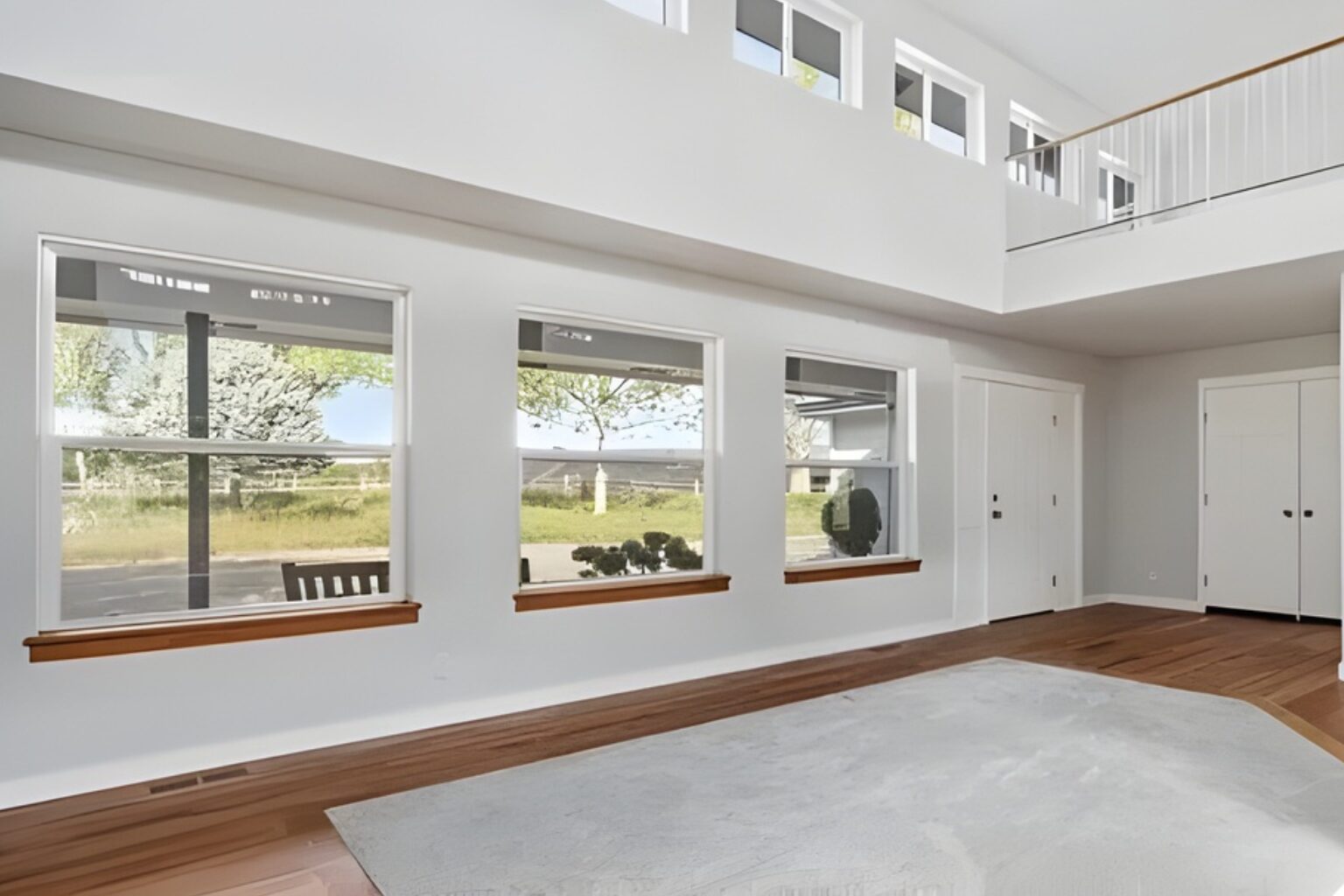 Spacious room with large windows and carpet.